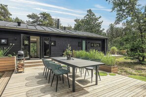 A modern house with a deck, outdoor seating, and a barbecue grill. - Summer house at Thyholm with fjord view (Thyholm)