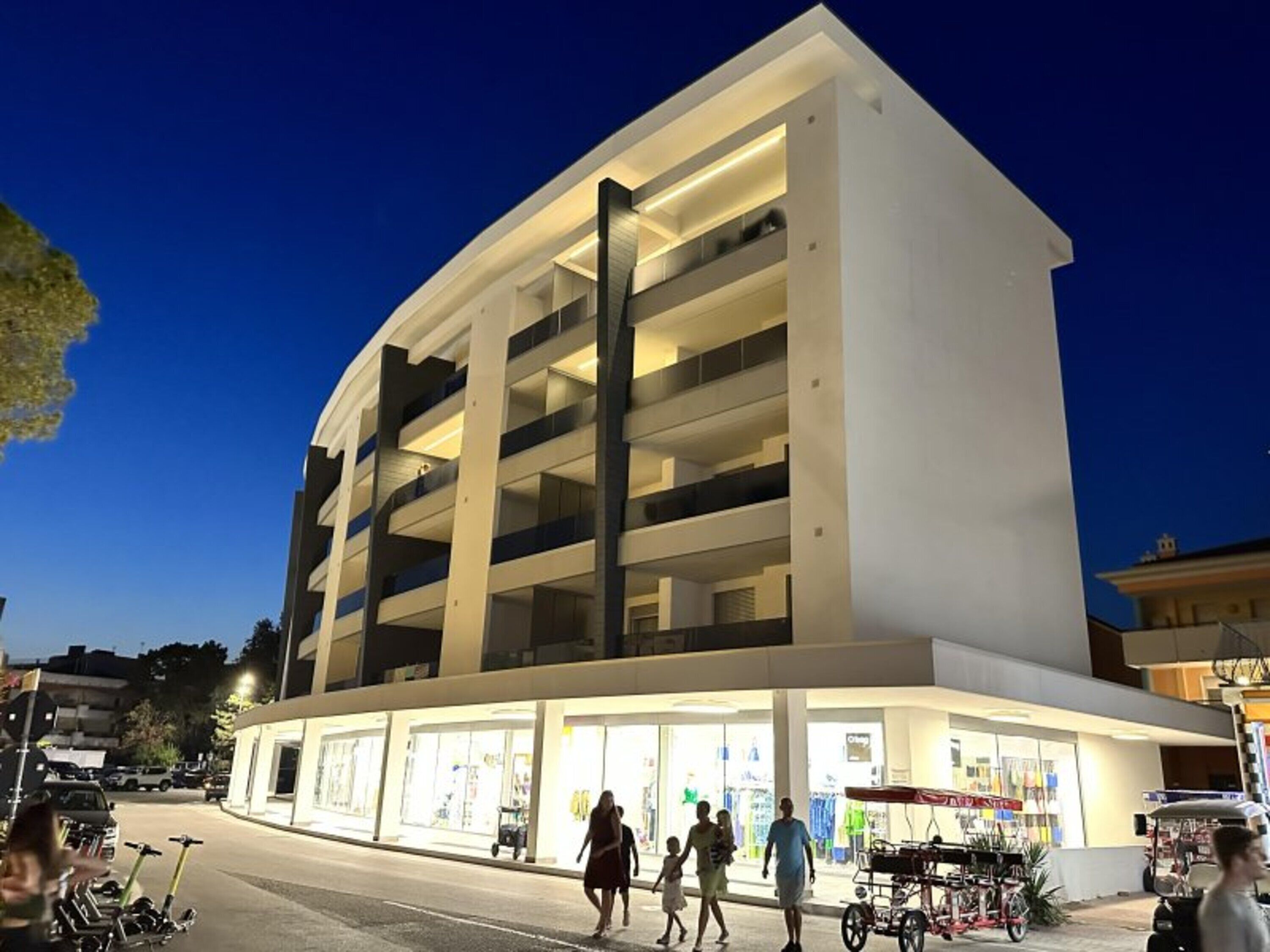 A multi-story parking structure with a flat roof and a ground-level retail area.
