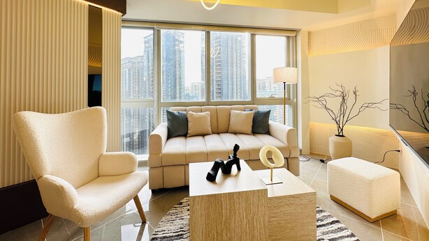 A modern living room with a sofa, armchair, coffee table, and decorative elements. - Cozy Sunlit Lounge w/ Balcony City View Uptown BGC (Taguig)
