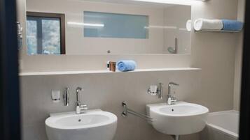 A bathroom with two sinks, a mirror, and a towel rack.