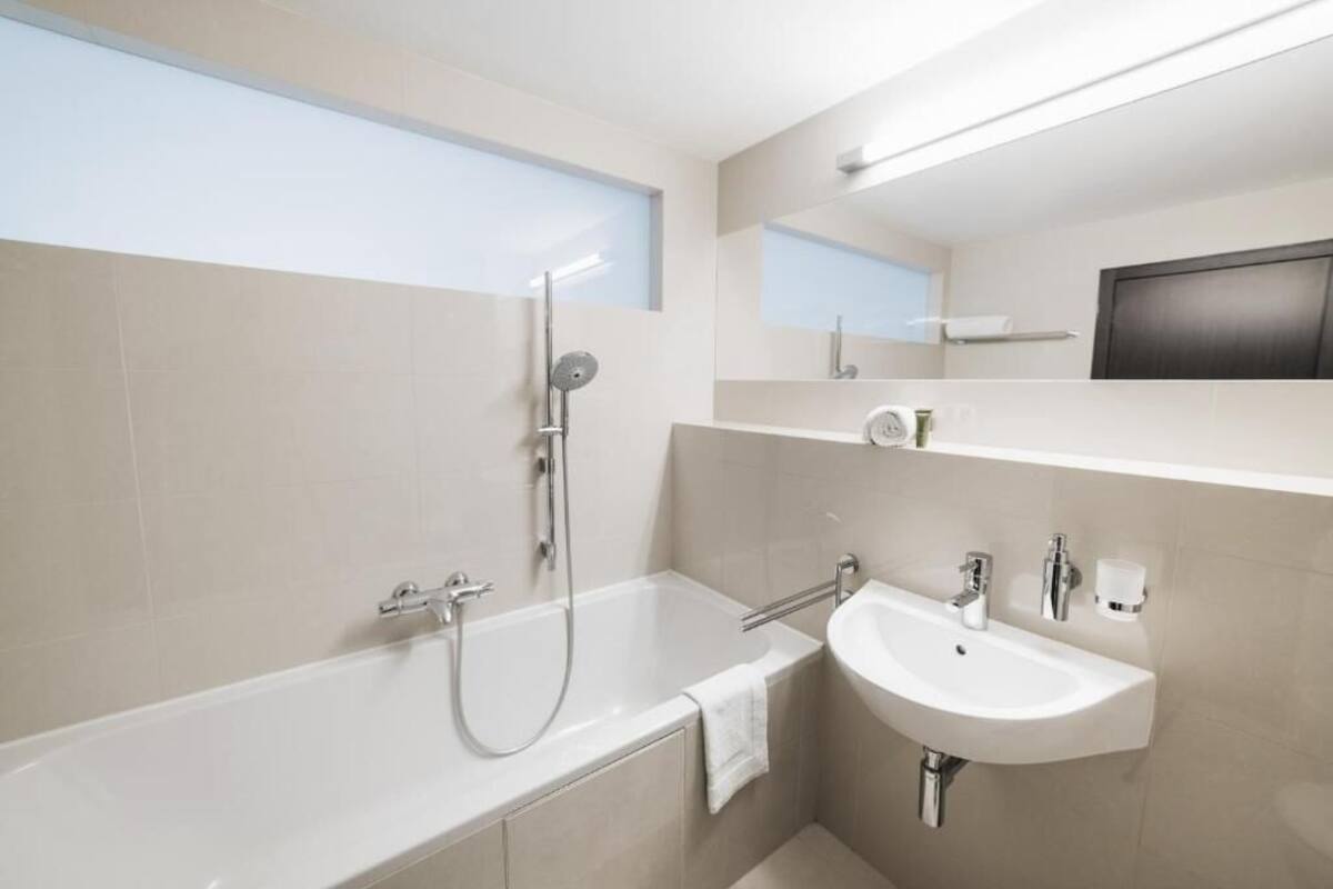Un baño moderno con bañera, ducha y lavamanos.