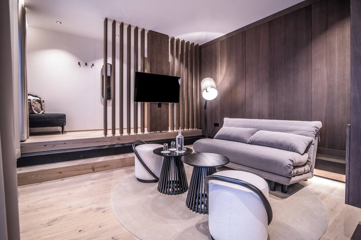 Una sala de estar moderna con un televisor de pantalla plana, un sofá y una mesa de centro.