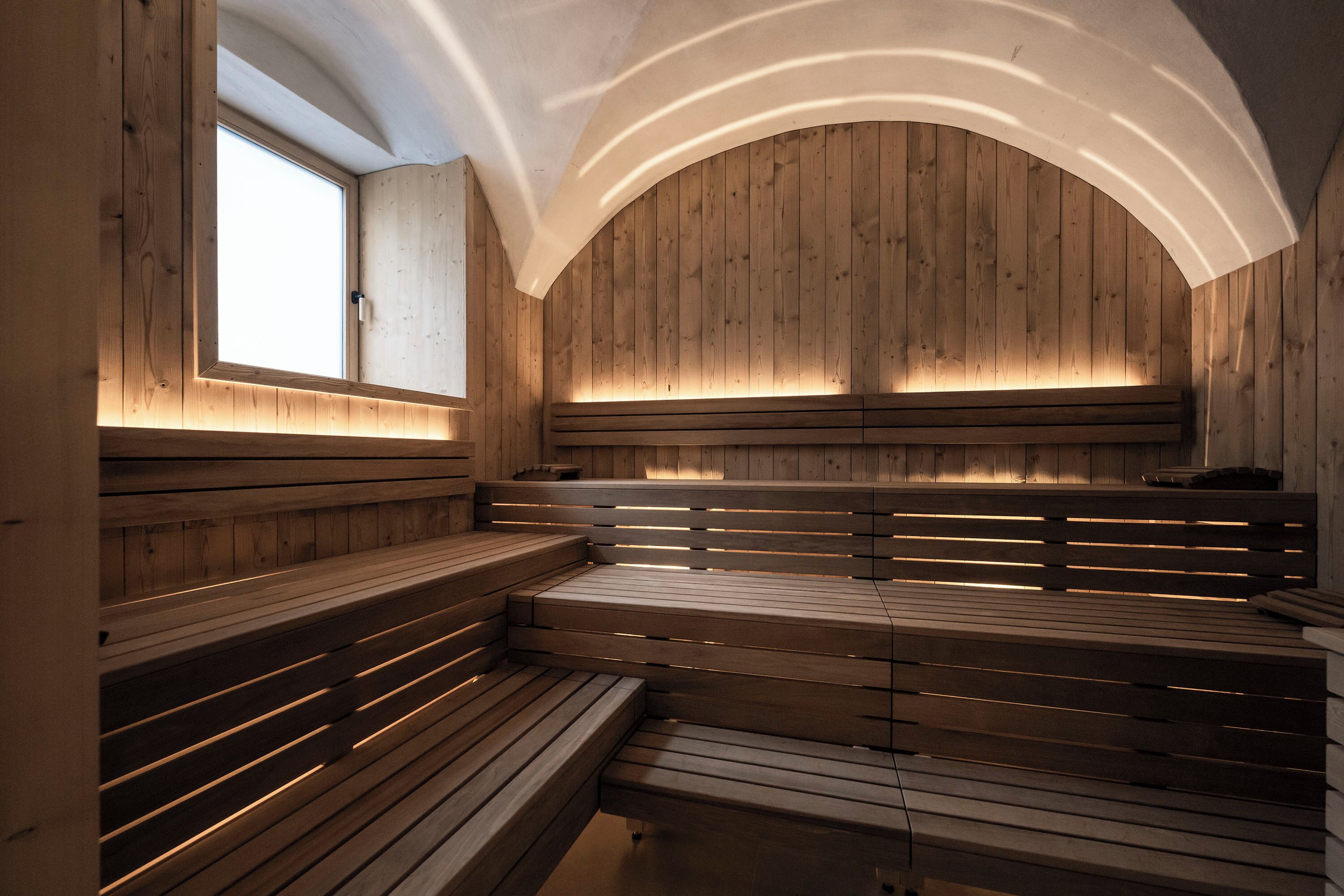 Una sauna con bancos de madera y techo inclinado.