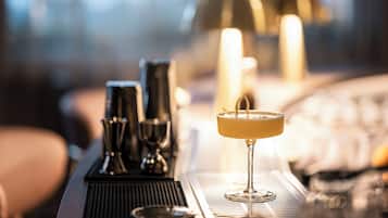 A bar area with a cocktail glass, bar tools, and candles.