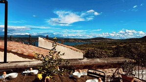 Ein Esszimmerstuhl draußen mit Blick auf Berge und einen See.