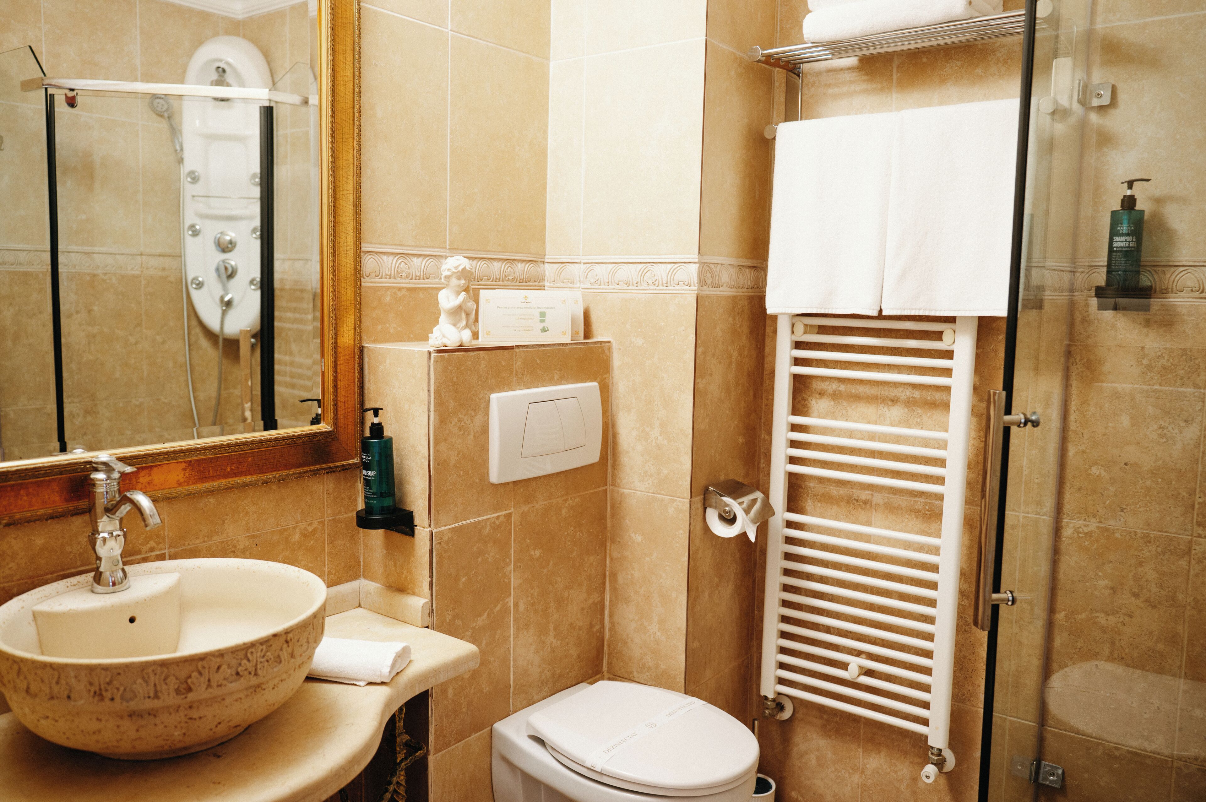Une salle de bain équipée d’un lavabo, de toilettes, d’une douche et d’un porte-serviettes.
