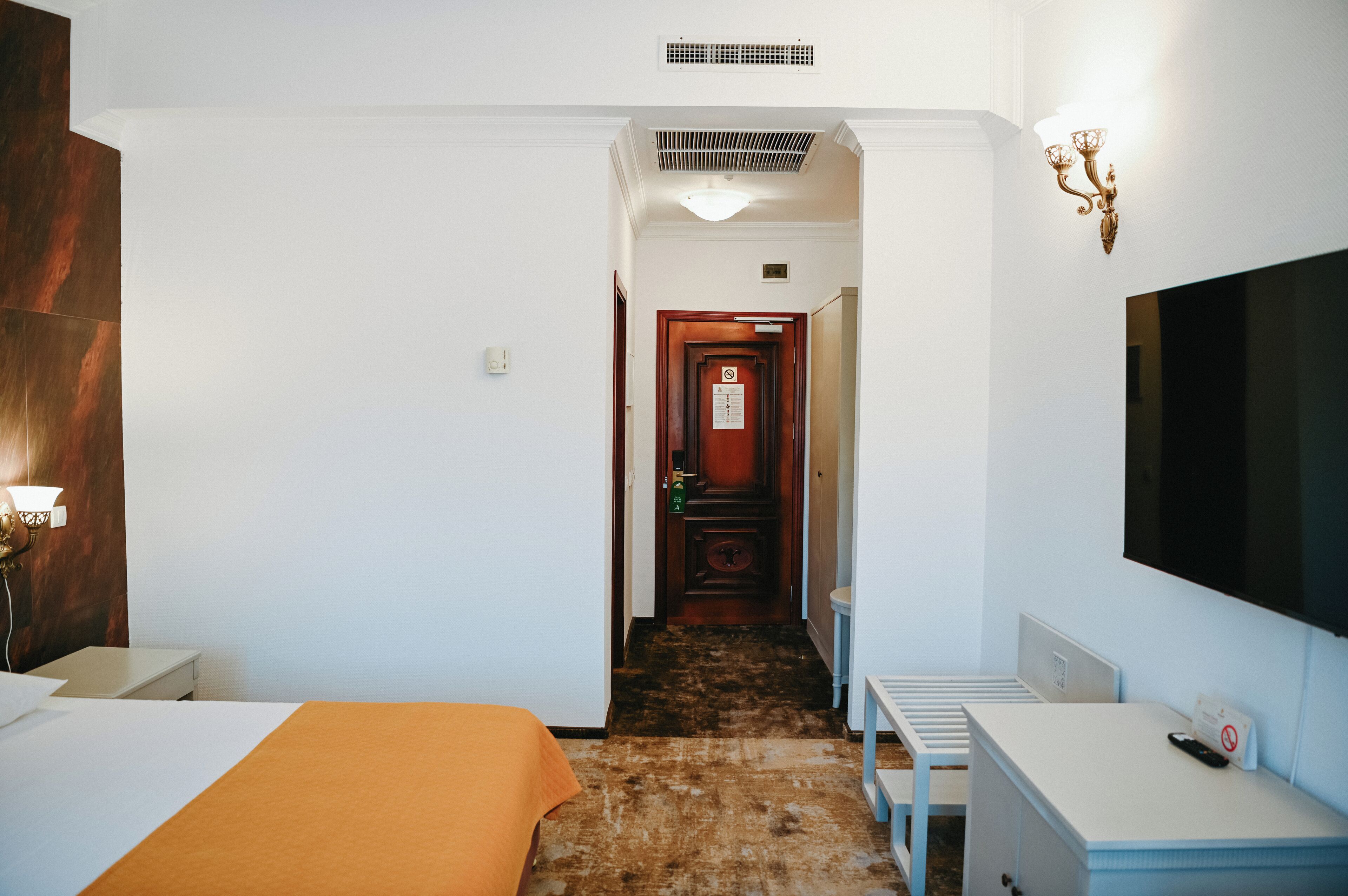 Una camera d'albergo con un letto, una scrivania, una televisione e un bagno.
