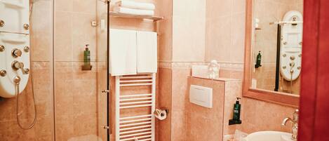 Un baño con ducha, inodoro, lavabo y espejo.