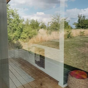 Ein Zimmer mit einem großen Fenster mit Blick auf eine grüne Fläche mit Bäumen.