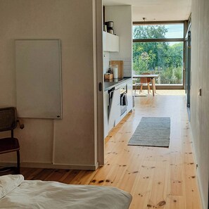 Ein modernes Interieur mit einem Bett, einer Küche und einem Essbereich mit Blick.