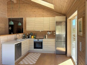 Eine moderne Küche mit Holzschränken, einem Edelstahlkühlschrank und einem Schachbrettteppich.