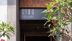 Una fachada con un letrero que dice 'CIAO BOUTIQUE' y una puerta de madera entreabierta.