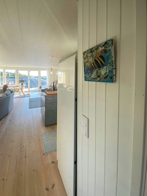 A spacious living area with a sliding glass door leading to a balcony, a dining area, and a kitchen. - Seaside house with pool near Hällevikstrand (Ellös)