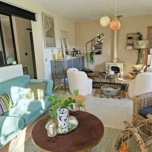 Ein Wohnzimmer mit einer Couch, einem Sessel, einem Couchtisch und einem Kamin.