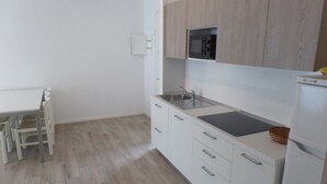 Eine moderne Küche mit weißen Schränken, einer eingebauten Mikrowelle und einem Spülbecken.