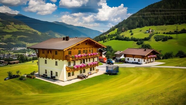 A two-story wooden chalet with balconies, surrounded by lush green fields and mountains. - Apartment "Panorama" with Mountain Views, Shared Garden, and Wi-Fi (Mittersill)