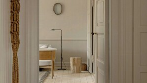 A hallway leading to a bedroom with a bed, bedside table, lamp, and a round mirror on the wall. - Exclusive holiday home by Tisvilde beach (Tisvildeleje)