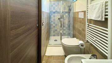 Un baño con ducha, inodoro y lavamanos.