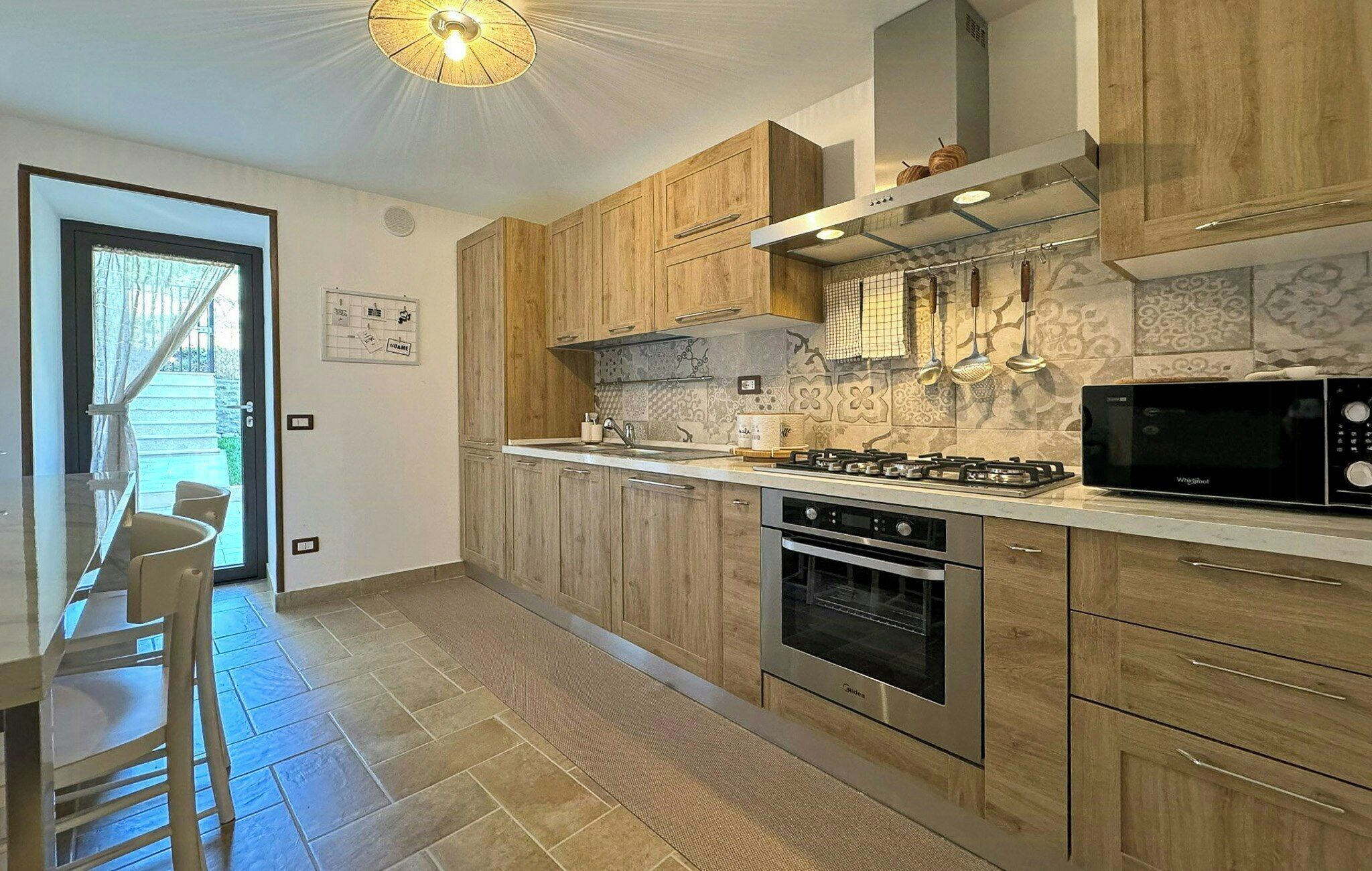 A modern kitchen with wooden cabinets, a gas stove, an oven, and a microwave.