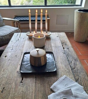 Ein Holztisch mit Kerzenhalter, Kerze und Tablett mit Deckel.