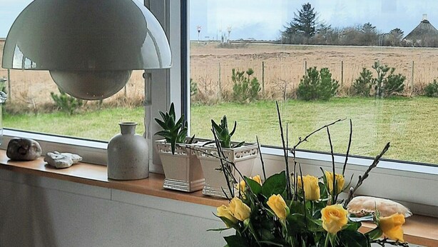 Ein Tisch mit Kerzen, einer Tablett und einer Vase mit gelben Blumen.