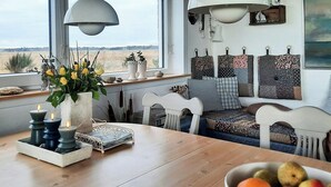 Ein gemütlicher Sitzbereich mit Blick auf die Landschaft, ein Tisch mit Kerzen und eine Obstschale.