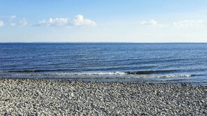 Ein Kiesstrand mit Blick auf den Ozean.
