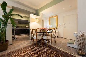 A dining area with a round table, chairs, a patterned rug, and a potted plant. - La Casa di Flora - 6-bedroom suite apartment with private parking (Florence)