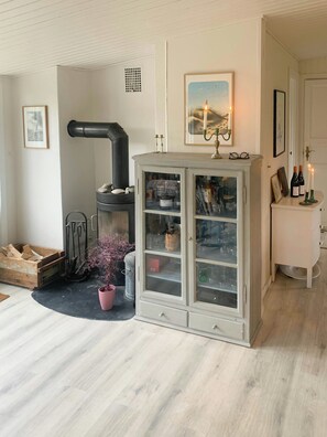 Una habitación con un armario blanco, una chimenea y una planta en maceta.
