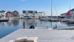 A marina with boats, a wooden dock, and buildings in the background.