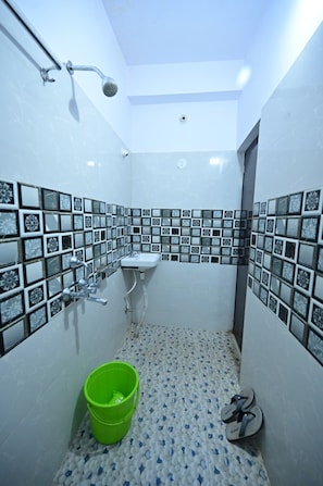 Une petite salle de bain avec douche, lavabo et carrelage décoratif.