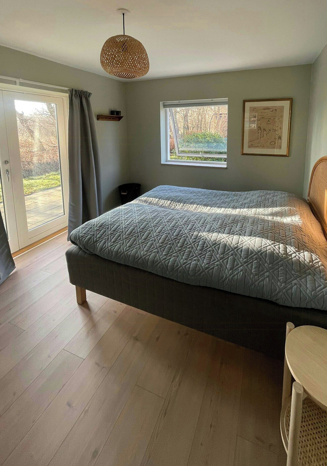 Une chambre à coucher avec un lit, une fenêtre, une porte et un luminaire au plafond.