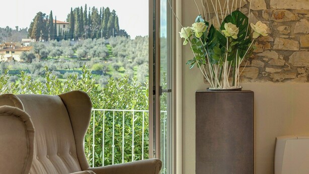 A room with a view of a rural landscape, a potted plant, and a modern sofa. - Villa with infinity pool in the Tuscan hills (Rignano sull'arno)