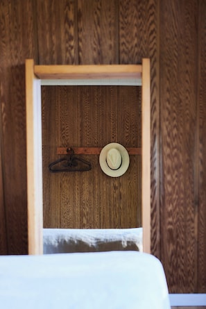 Ein Fenster mit Holzrahmen, an dessen Innenseite ein Hut und ein Kleiderbügel hängen.