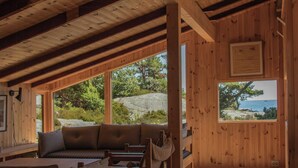 A wooden interior with a sofa, a bench, and a window offering a view of the outdoors.