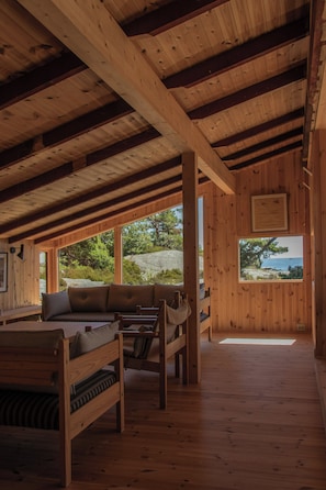 Un intérieur en bois comprenant un canapé, un banc et une fenêtre donnant sur l’extérieur.