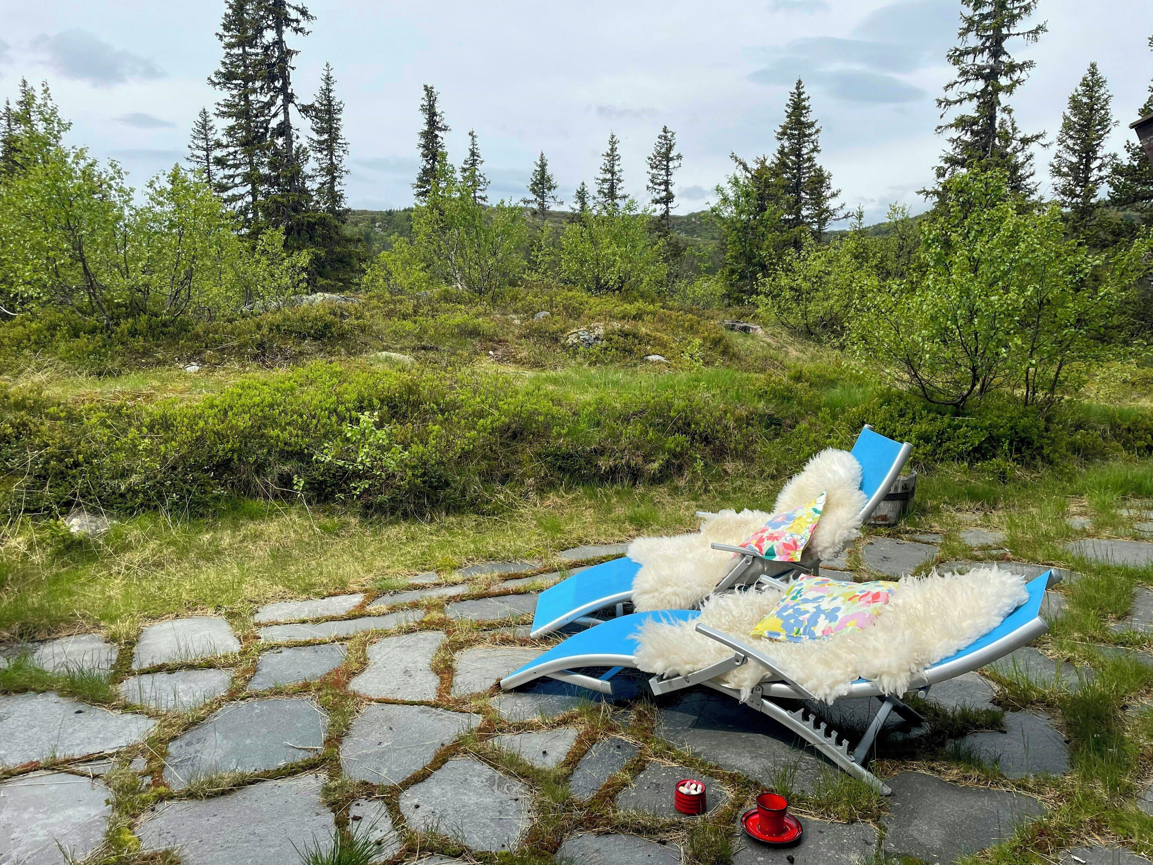 A stone-paved area with two lounge chairs, one overturned, and a red cup on the ground.