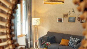 A living room with a sofa, a coffee table, a lamp, and a wall with pictures. - Eco-friendly gite in a wine estate in Frontignan (Frontignan)