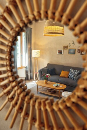 A living room with a sofa, a coffee table, a lamp, and a wall with pictures. - Eco-friendly gite in a wine estate in Frontignan (Frontignan)