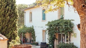 A courtyard with a building, a wooden barrel, and string lights. - Eco-friendly gite in a wine estate in Frontignan (Frontignan)