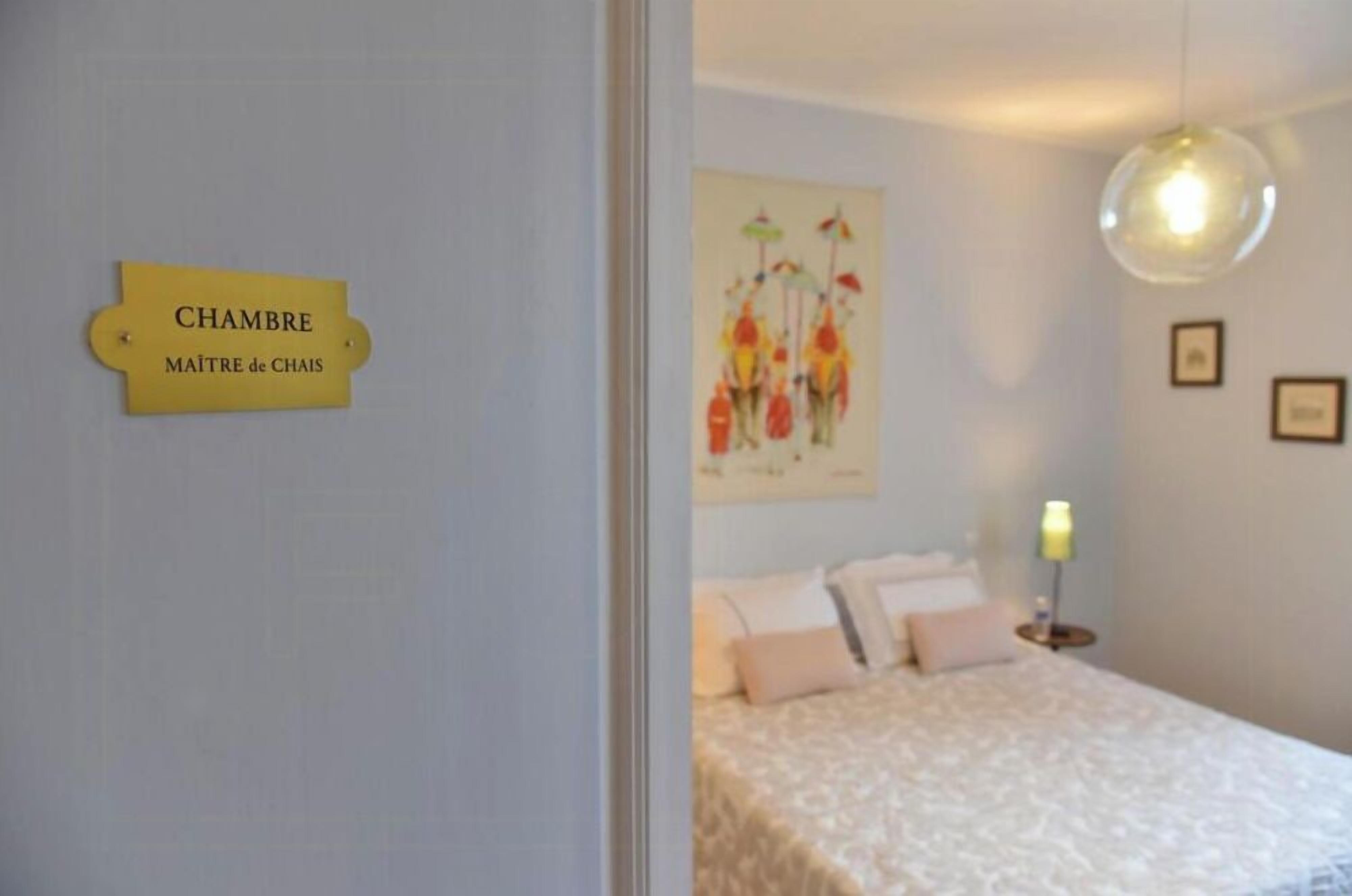 A bedroom with a bed, a nightstand, a lamp, and a wall-mounted artwork.