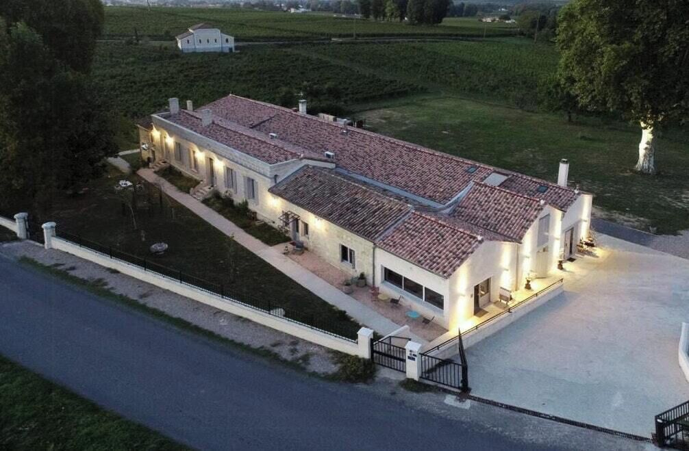 Un grand bâtiment d’un seul étage, doté d’un toit recouvert de tuiles, d’une allée pavée et d’une pelouse bien entretenue.
