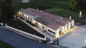 Un grand bâtiment d’un seul étage, doté d’un toit recouvert de tuiles, d’une allée pavée et d’une pelouse bien entretenue.