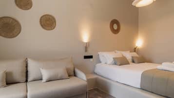 A modern bedroom with a sofa, a bed, and decorative wall hangings.