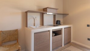 A modern bathroom with a built-in sink, a mirror, and storage cabinets. - Ichos Apartments (Volissos)