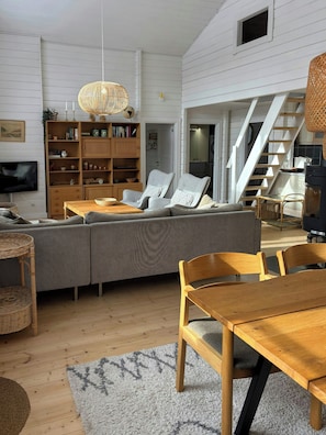 Ein modernes Wohnzimmer mit einer Couch, einem Holztisch und einem Bücherregal.