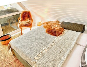Ein Zimmer mit Bett, Stuhl, Lampe und Fenster.