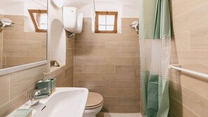 Une salle de bain avec une baignoire, des toilettes et une douche.