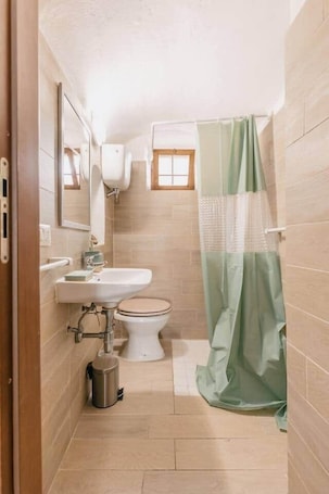 Une petite salle de bain avec des toilettes, un lavabo et un rideau de douche.. BHR - Il Nido di Trevi