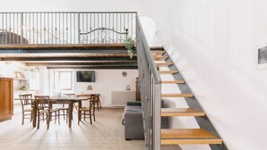 Un intérieur moderne comprenant un coin repas, un escalier et un espace de vie.